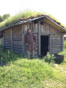 Så här kan grophus ha sett ut under vikingatiden. Rekonstruktionen finns på Gunnes gård, där arkeologen Anders Liliehöök, som står vid dörröppningen, är verksam.